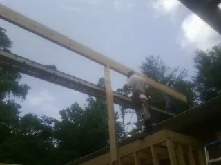 Carpenter setting a ridge beam over a new addition frame — Ice Dam Removal by Roofing Brothers in Foxhome