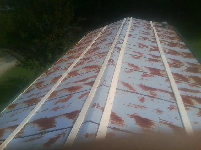 Rusted metal roof panels with new wood purlins before replacement — Storm Damage Roof Repair in Foxhome by Roofing Brothers