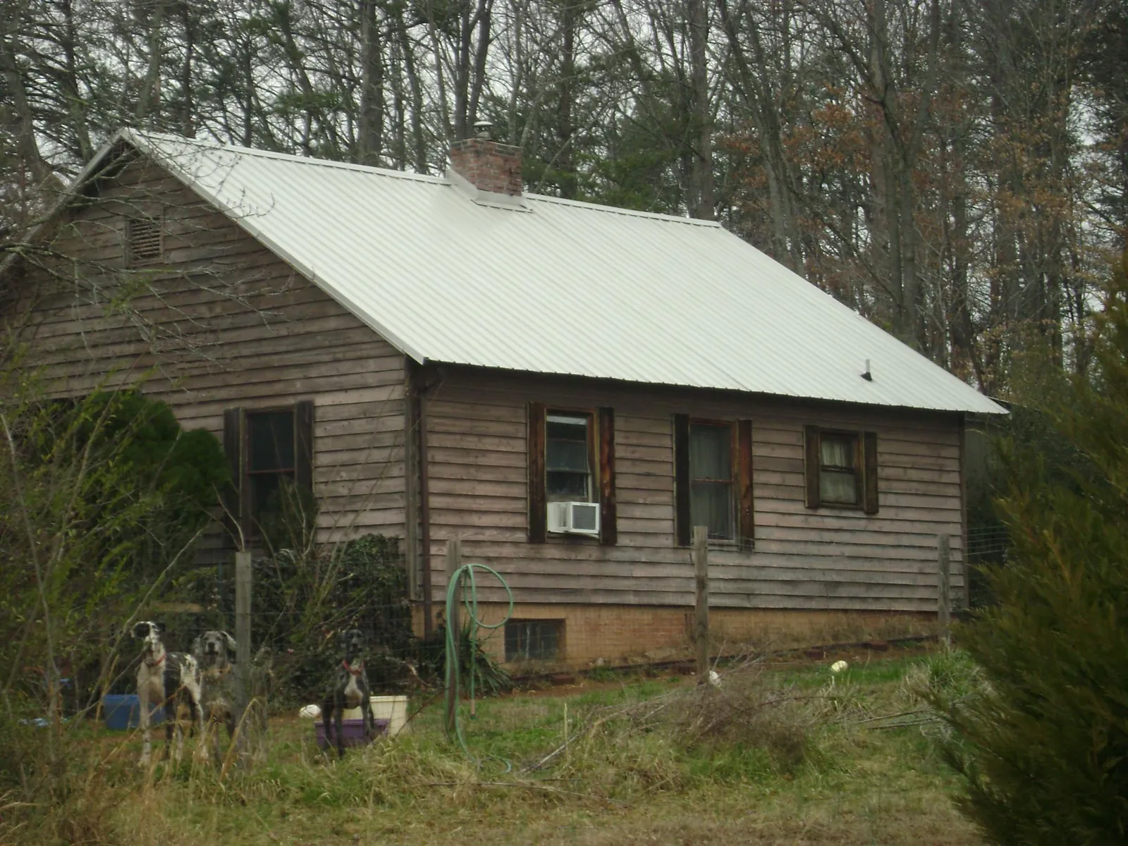 White metal roof on an old wood sided farmhouse, from a Metal Roof Installation job in Foxhome